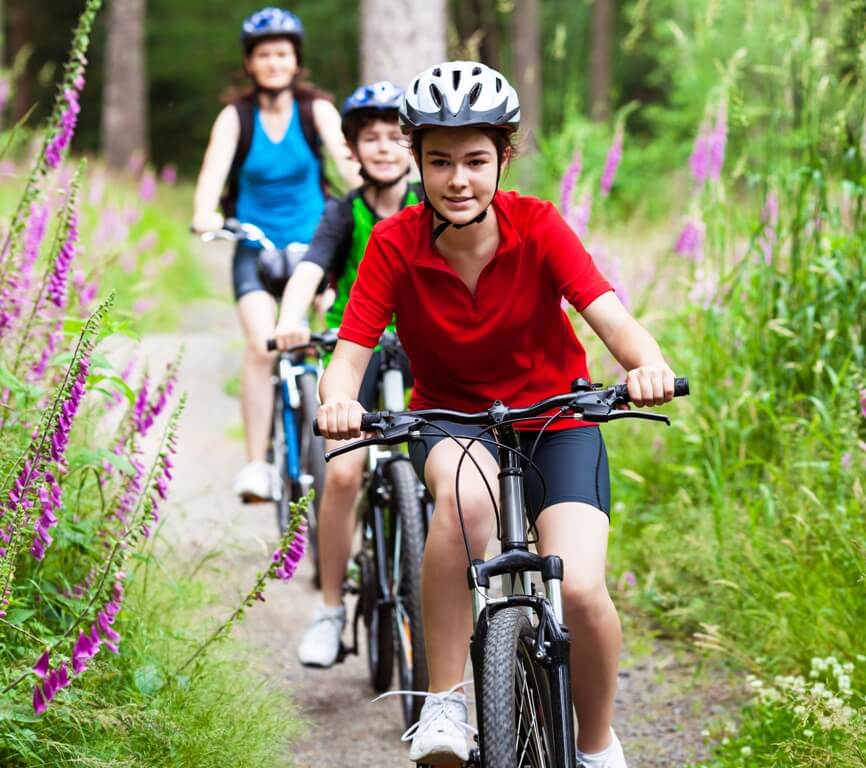 Family biking on a grassy trail.