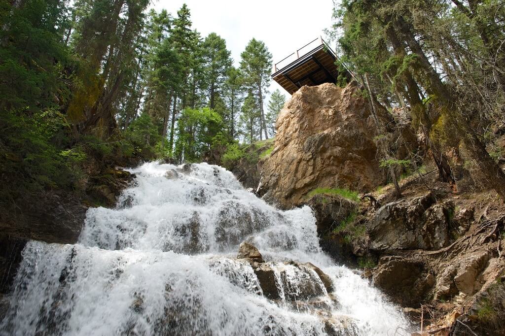 Photo taken from bottom of waterfall, looking up, with viewpoint deck at the top.